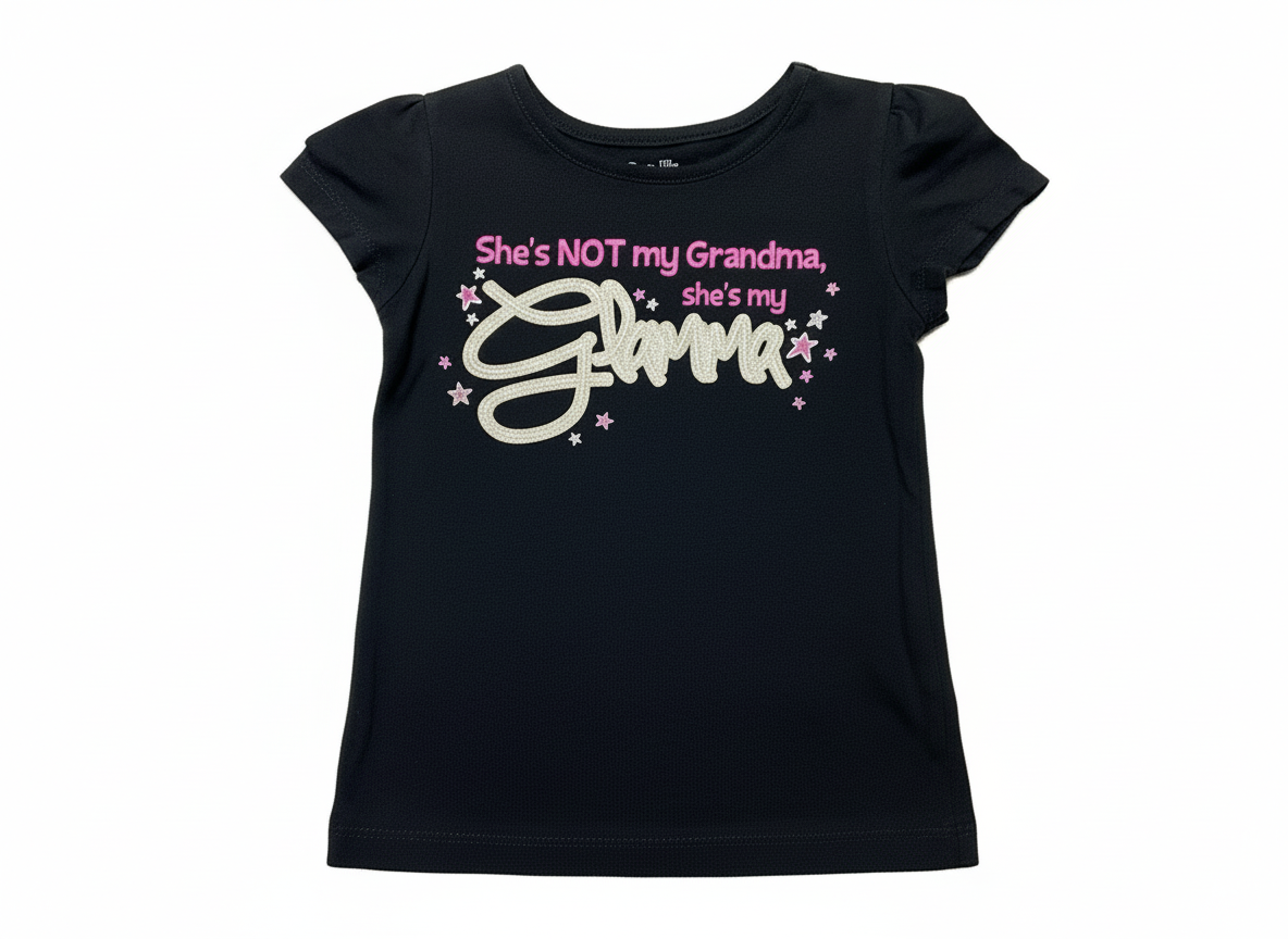 Studio flat lay of black She's My Glamma t-shirt with professional lighting
