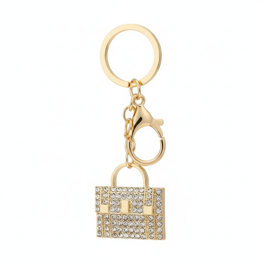 Gold rhinestone handbag keychain charm with chain link and gold keyring on white background
