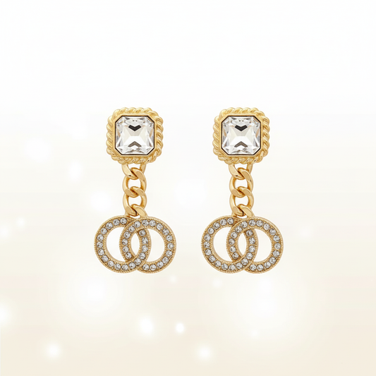 Pair of gold double circle drop earrings on clean white backdrop with bright lighting, showcasing 2.5-inch length, cushion-cut crystal studs, and pavé rhinestone double circle pendants