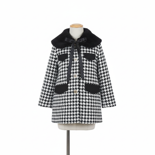 Black and white houndstooth coat with detachable faux fur collar on clean white background, minimalist styling