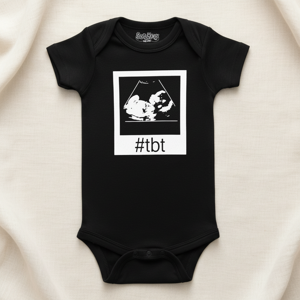Black baby onesie with white polaroid ultrasound graphic and #tbt text, premium flat lay on ivory linen background, boutique baby clothing photography