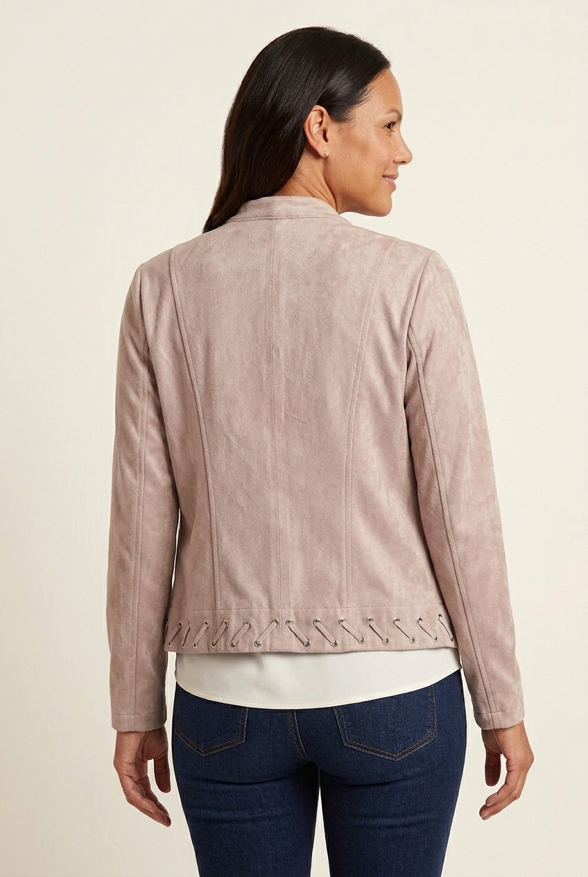 Back view of blush faux suede jacket showing vertical panel seams, long sleeves and diagonal lacing through metal eyelets along the hem.