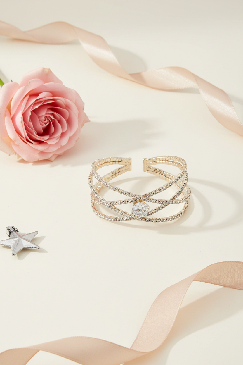 Minimalist holiday image of gold rhinestone cuff bracelet with soft pink and gold accents