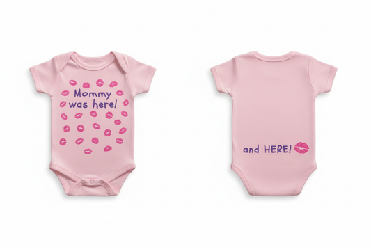 Pink baby onesie front and back views showing "Mommy was here!" with pink glitter kiss prints on front and "and HERE!" with pink glitter kiss on back on white background
