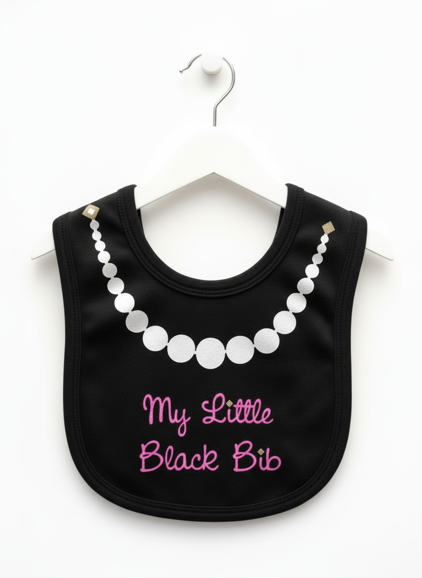 Black baby bib with white glitter pearl necklace graphic and hot pink glitter script text reading 'My Little Black Bib' hanging on white hanger against white background
