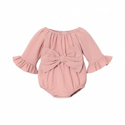 Baby girl pink onesie with ruffle sleeves and large bow on white background