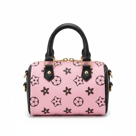 Pink cylinder handbag for girls with black monogram star print and black handles on white background