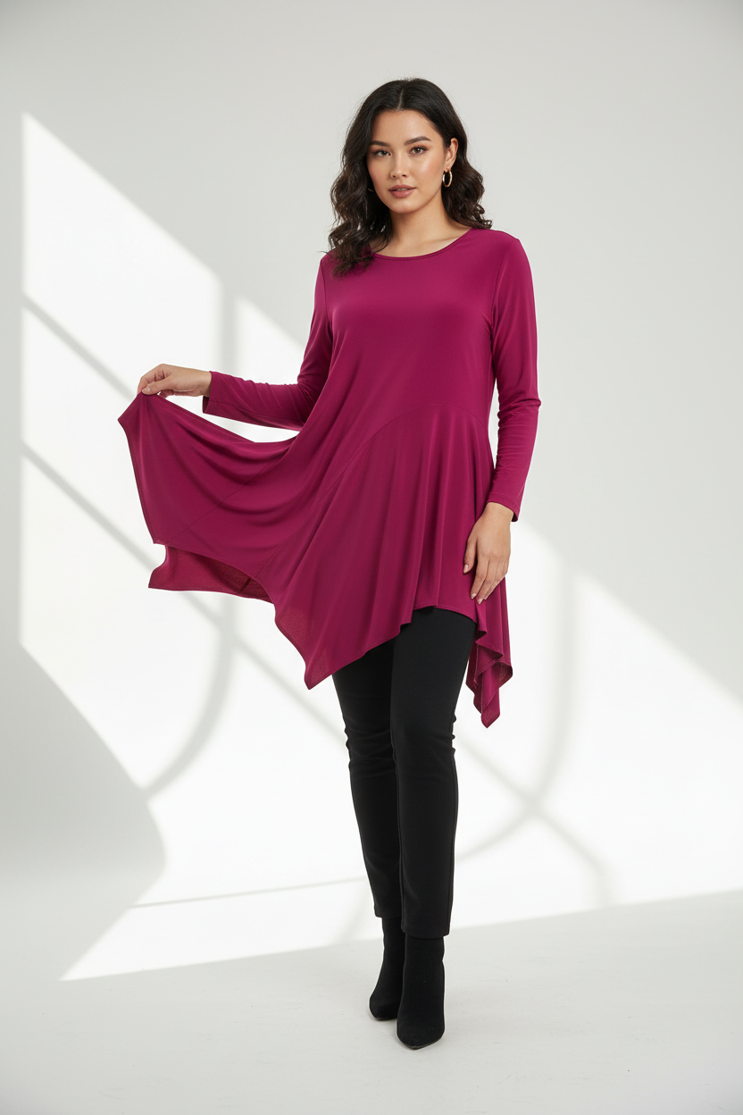 Full-length studio portrait of woman in vibrant magenta asymmetric tunic with flowing handkerchief hem styled with black leggings, clean white background with natural light shadows