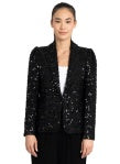 Woman wearing a black sequin blazer against a plain background