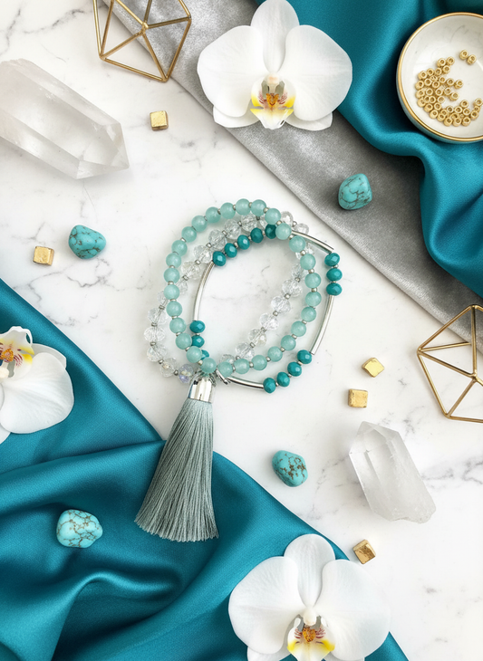 Turquoise and silver crystal stretch bracelet set with tassel arranged on white marble with elegant styling - luxury jewelry flat lay